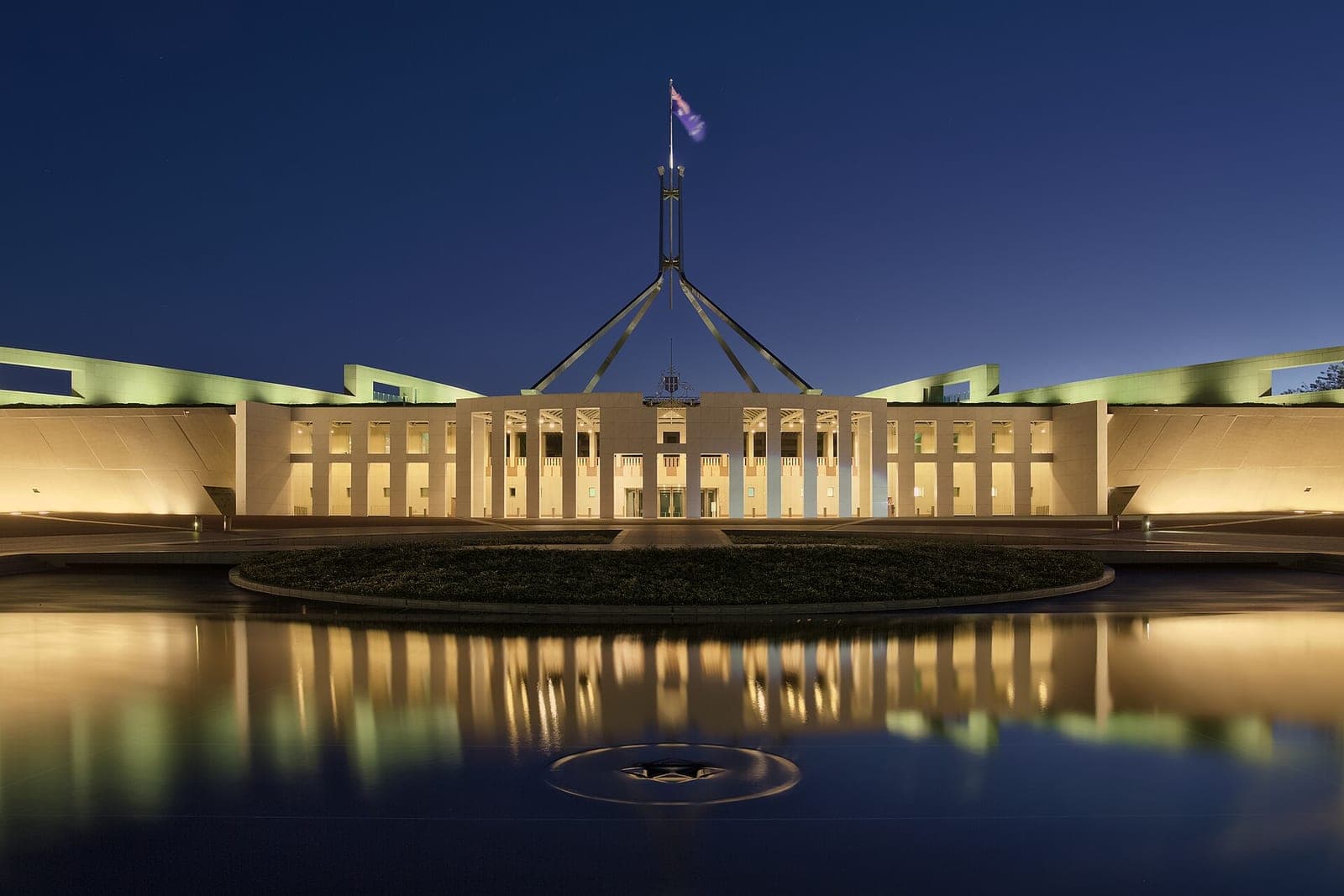 Australia's Parliament House in Canberra at dusk, reflected in the forecourt pool